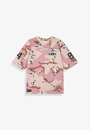 Różowo-beżowa koszula w krótki rękaw z wzorem kamuflażu, z czarnymi cyframi „4” na lewym rękawie i „8” na prawym rękawie oraz małym białym napisem na klatce piersiowej.