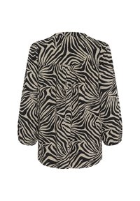 Blouse à motifs zèbre noir et beige avec manches longues, coupe décontractée, plis dans le dos et ourlet arrondi. Texture de tissu léger.