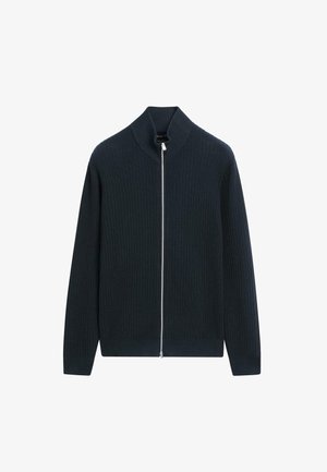 Navy ribgebreide kardigan met een hoge kraag en lange mouwen. Voorzien van een zilveren ritssluiting over de volledige lengte, wat een gestructureerde pasvorm biedt.