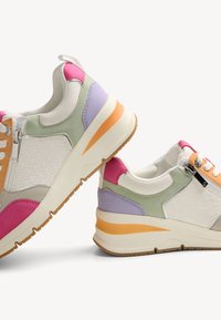 Multikleur sneakers met een mix van witte, groene, roze, paarse en oranje tinten, voorzien van een gestructureerd zijpaneel en een ritsaccent.