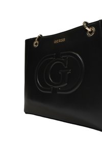 Schwarze Handtasche aus Kunstleder mit eingeprägtem Logo, glänzendem goldenen Beschlägen und Kettenakzenten. Glatte Textur, strukturierte Form, minimalistisches Design.
