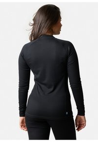 Black long-sleeve top with a ribbed texture, featuring a round neckline and fitted design. A small blue and yellow tag is visible at the hem.