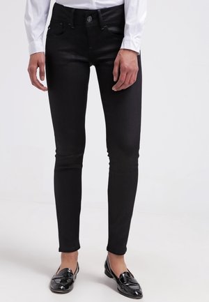Vaqueros negros ajustados de denim elástico, con una cintura de altura media, diseño de cinco bolsillos y una textura suave y atractiva.