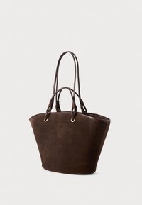 Brown suede tote bag with two long, textured handles and gold-tone eyelets. The bag features a wide, open top and a structured, tapered shape.