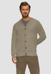 Khakifarbener Cardigan mit V-Ausschnitt, gerippten Bündchen und Saum, ausgestattet mit sechs schwarzen Knöpfen. Getragen über einem grauen T-Shirt, mit strukturierten Cordhosen.