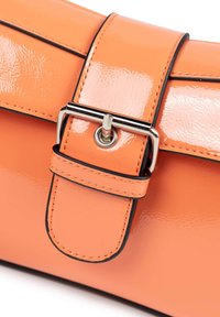 Oranje lakslederen tas met een gepolijste sluiting en zwarte accenten op de randen, met een gestructureerd ontwerp en glanzende textuur.