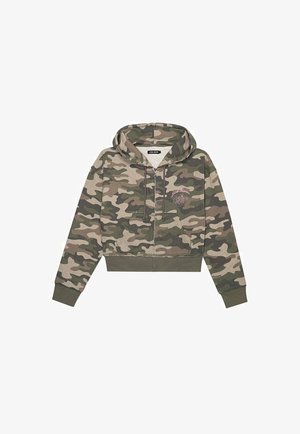 Krótkia bluza z kapturem zapinana na zamek błyskawiczny w zielonym i brązowym wzorze kamuflażu, z małym haftowanym kwiatkiem oraz napisem "lokalny kwiat" na piersi.