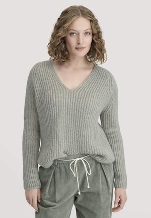 Maglione grigio chiaro a costine con scollo a V, maniche lunghe e vestibilità rilassata, abbinato a pantaloni in corduroy verdi, morbidi e con cordoncino.