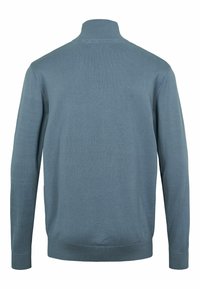Világoskék pulóver magas gallérral, hosszú ujjal, bordázott mandzsettával és szegéllyel. Simaság jellemzi, testhezálló kialakítással és látható minták nélkül.
