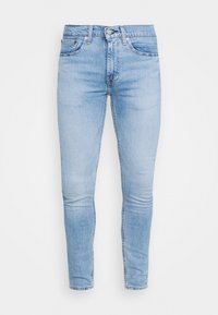 Jeans ajustados de mezclilla azul claro, con un diseño clásico de cinco bolsillos, cierre frontal con botones y un sutil desgaste a lo largo de las piernas.