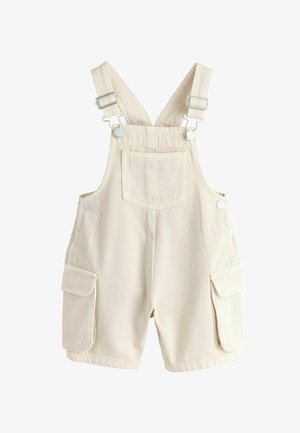 Kreminės spalvos vaikiškos puskombinezono kelnės su reguliuojamomis petnešėlėmis, priekinė krūtinės kišenė ir šoninės kišenės su atvartais ant balto fono.