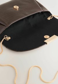 Braune Umhängetasche aus Kunst-Krokodilleder mit goldfarbenem Verschluss und schwarzer Stoffauskleidung. Kettenriemen sichtbar.