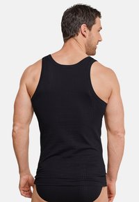 Zwarte geribbelde tanktop met een ronde hals en brede armsgaten, voorzien van een aansluitend ontwerp en een gladde textuur.