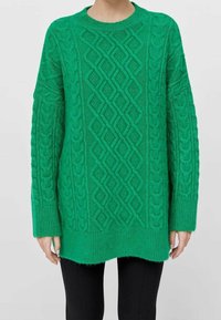 Pull vert en maille torsadée avec un col rond, des manches longues et un motif texturé en forme de losange, comprenant des poignets et un ourlet côtelés.