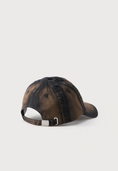 Καφέ και μαύρο tie-dye καπέλο μπέιζμπολ που βρίσκεται στο πλάι με ρυθμιζόμενο λουράκι και μεταλλικό κούμπωμα σε λευκό φόντο.