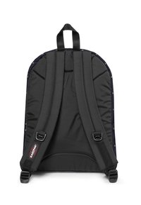 Musta pehmustettu reppu säädettävillä olkahihnoilla, jossa on kultaiset niitit reunoilla ja yläkahva helppoa kantamista varten.