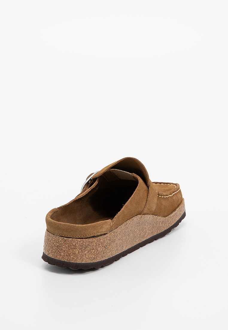 Brązowy zamszowy but wsuwany z korkową podeszwą, okrągłym noskiem i prostymi detalami szycia, z wkładką amortyzującą dla komfortu.