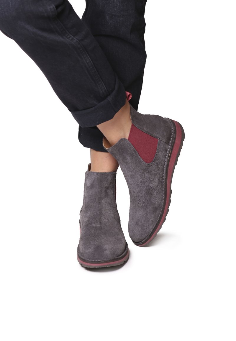 Stivaletti ankle in suede grigio con pannelli elastici bordeaux ai lati, suola piatta in gomma e design a punta rotonda. Finitura testurizzata con dettagli in cucitura.