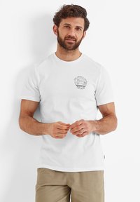 White cotton t-shirt featuring a round neckline and short sleeves, with a black circular graphic print on the left chest.