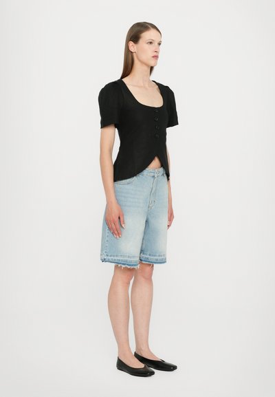 Svart kortermet topp med firkantet utringning og frontknapper, parret med lyseblå denimshorts med frynsekant og avslappet passform.