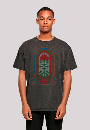 Grey oversized t-shirt with a printed design featuring a red rose and green leaves, framed in colorful accents, labeled "STRANGER THINGS."