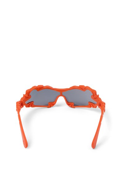 Sonnenbrille mit gezackten, flammeninspirierten, hellorangefarbenen Rahmen und dunklen Gläsern, von vorne vor weißem Hintergrund gezeigt.