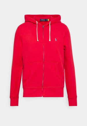Czerwona bluza z kapturem na zamek, z białymi sznurkami, przednimi kieszeniami i małym niebieskim logo Polo Ralph Lauren na lewej piersi.