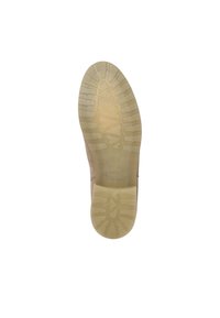 Suola di una scarpa, con una parte inferiore in gomma strutturata di colore beige chiaro, dotata di una presa decorata e scanalature per la trazione. Bordo superiore liscio.
