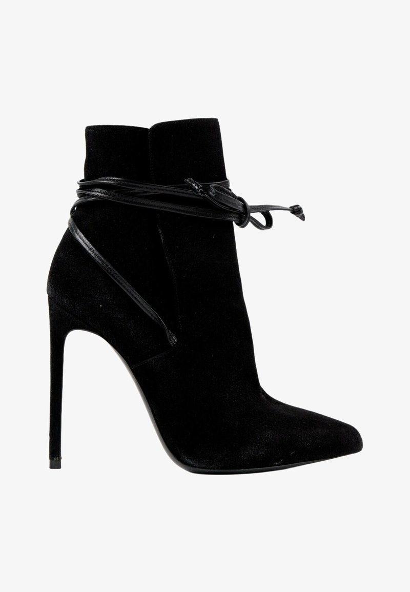Bottine noire en daim à talon haut avec bout pointu et fins lacets en cuir enroulés autour et noués à l'avant.