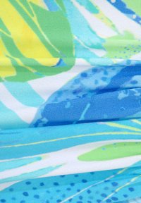 Tessuto colorato con vivaci motivi astratti blu, giallo e verde, con una texture liscia e una leggera lucentezza, piegato per creare profondità.