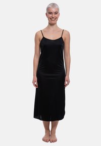 Abito nero aderente realizzato in un tessuto leggero e morbido. Presenta spalline sottili regolabili e una lunghezza midi, con una silhouette semplice ed elegante.