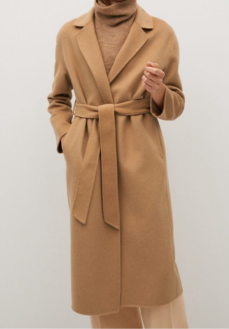 Manteau en laine camel avec ceinture, revers crantés, manches longues et poches latérales. Texture douce et design structuré, silhouette mi-longue.