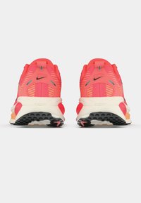 Αντιολισθητικά παπούτσια Nike για τρέξιμο με έντονο ροζ άνω μέρος από δίχτυ, λαστιχένια εξωτερική σόλα και κρεμ ενδιάμεση σόλα. Διαθέτουν λωρίδες αερισμού και μαύρες λεπτομέρειες.