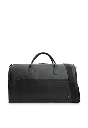 Sort læderrejsetaske med lynlåslomme foran, dobbelthåndtag og justerbar skulderrem på hvid baggrund.