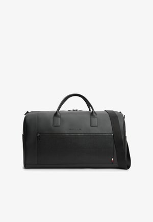 Bolsa de viaje de cuero negro con bolsillo frontal con cremallera, dos asas y correa de hombro ajustable sobre un fondo blanco.