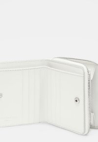 Biały portfel na zamek wykonany z gładkiej skóry. Wewnątrz znajduje się wiele miejsc na karty, zapięcie na zatrzask oraz srebrne detale zamka.