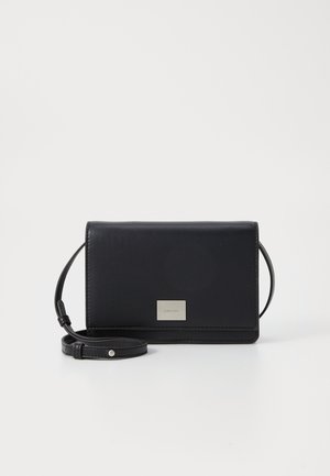 Bolso cruzado de cuero negro con forma rectangular, correa desmontable y placa de logo en tono plateado en la parte frontal. Textura suave.