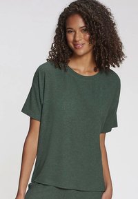 Zaļš ribots īsroku tops ar apaļu kakla izgriezumu. Mīksta tekstūra un vaļīga piegriezums, ar smalku šuvju detaļu uz piedurknēm.