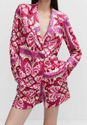 Conjunto de satén rosa y crema con estampado que incluye una chaqueta con un escote en V profundo y pantalones cortos a juego, mostrando diseños ondulados y una textura brillante.