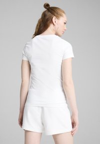 Witte t-shirt met korte mouwen van zachte stof, met een ronde hals en slim fit, gecombineerd met witte shorts, gezien van de achterkant.