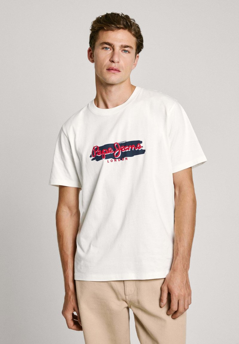 Camiseta de algodón blanca con un logo gráfico en rojo y azul marino que presenta el texto "Pepe Jeans London" en el pecho. Mangas cortas, cuello redondo.