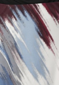 Abstrakt tyg med strimmor av vinröd, blå, grå och vit i en mjuk textur, vilket skapar ett dynamiskt, blandat mönster.