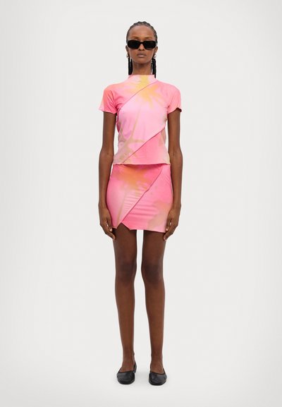 Short-sleeve, pink tie-dye top with diagonal seams paired with a matching, asymmetrical mini skirt. Smooth fabric, fitted design.