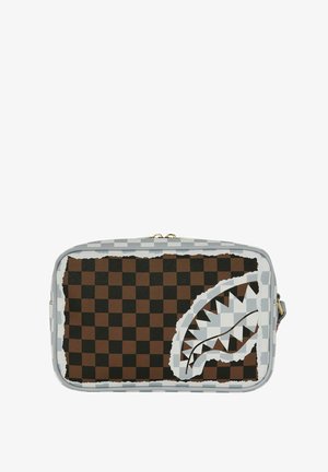 Bolsa rectangular con patrón de tablero de ajedrez en marrón y negro, borde de cremallera gris y gráfico estilizado de boca de tiburón desgarrada en la parte frontal.