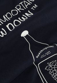 T-shirt color navy con testo stampato bianco e un grafico di una bottiglia di vino con un'illustrazione di uva e l'etichetta "Spätburgunder".