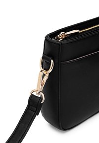 Černá syntetická kožená crossbody taška se zlatým zipem a hardwarem. Má odnímatelný popruh a hladký, strukturovaný tvar.