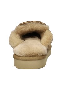 Bruine schapenleren pantoffel met een pluche, beige vachtvoering en zachte buitenkant. Voorzien van een ronde neus en een gestructureerde zool.