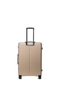 Harde koffer in metallicgoud met verticale ribbeltextuur, uitschuifbare zwarte handvat en vier rolwielen voor stabiliteit.