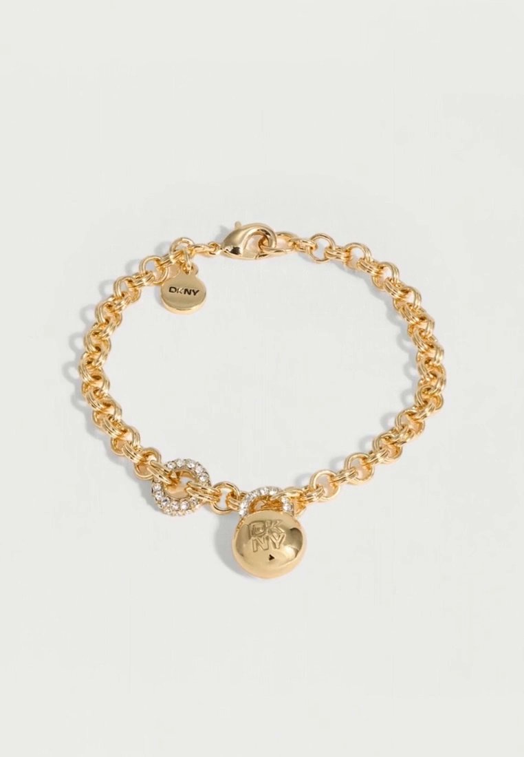 Bracelet chaîne DKNY doré, avec fermoir mousqueton, détails en cristal et breloque ronde ornée du logo, sur fond clair.
