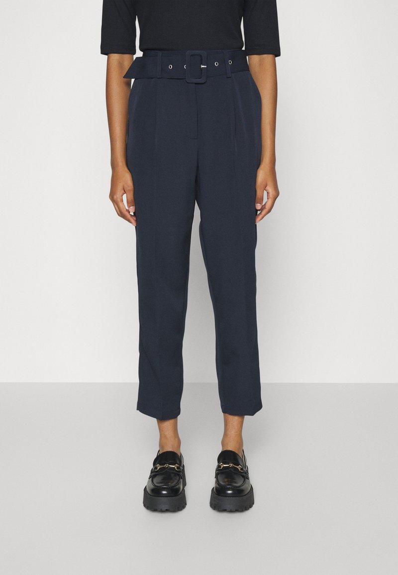 Marina höga byxor med breda bälten och spänne, med framveck och en skräddarsydd passform. Matchade med svarta platåskor.